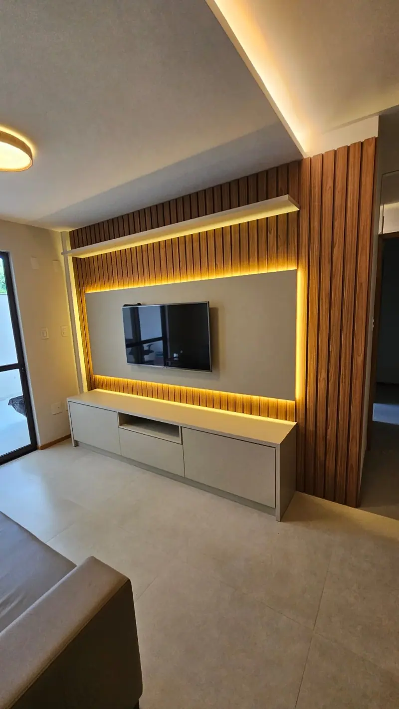 Painel de TV ripado com moldura iluminada por LED e rack claro