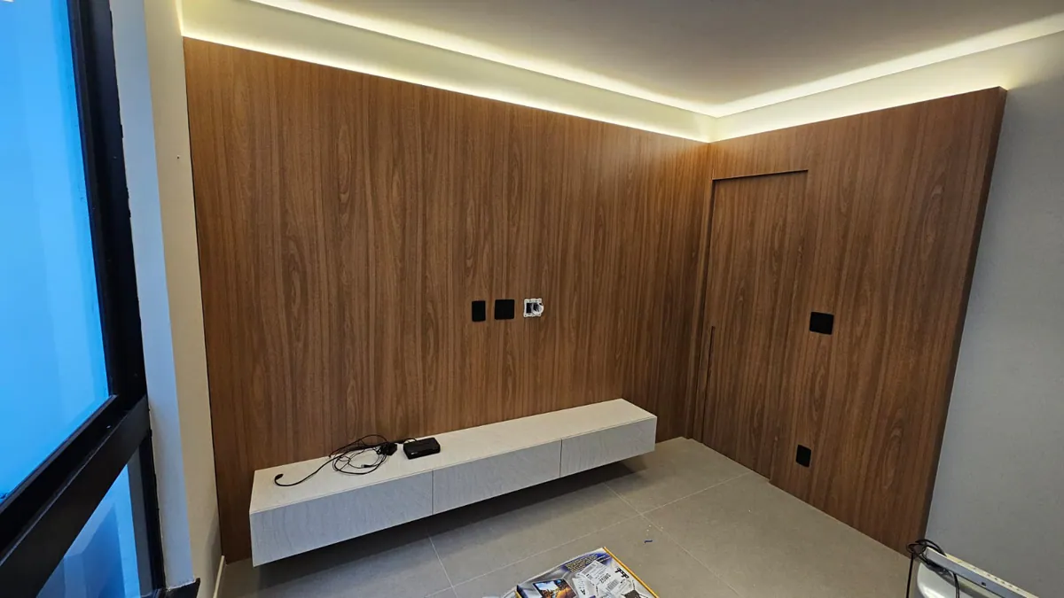Painel em madeira escura com porta oculta: Sala